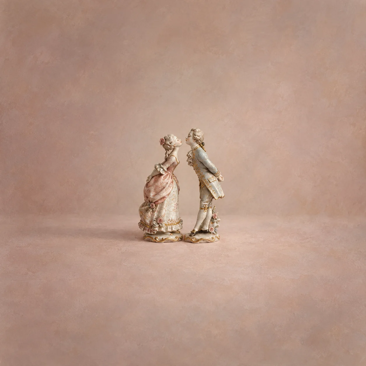 Painterly two porcelain figures leaning stiffly towards one another against dusty pink.