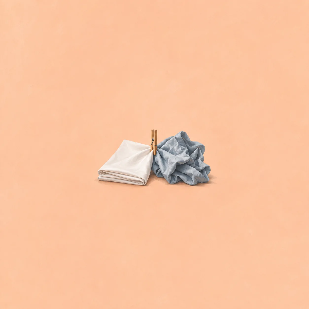 One folded white sheet and one crumpled blue-grey sheet joined by a clothespin on a peach background.
