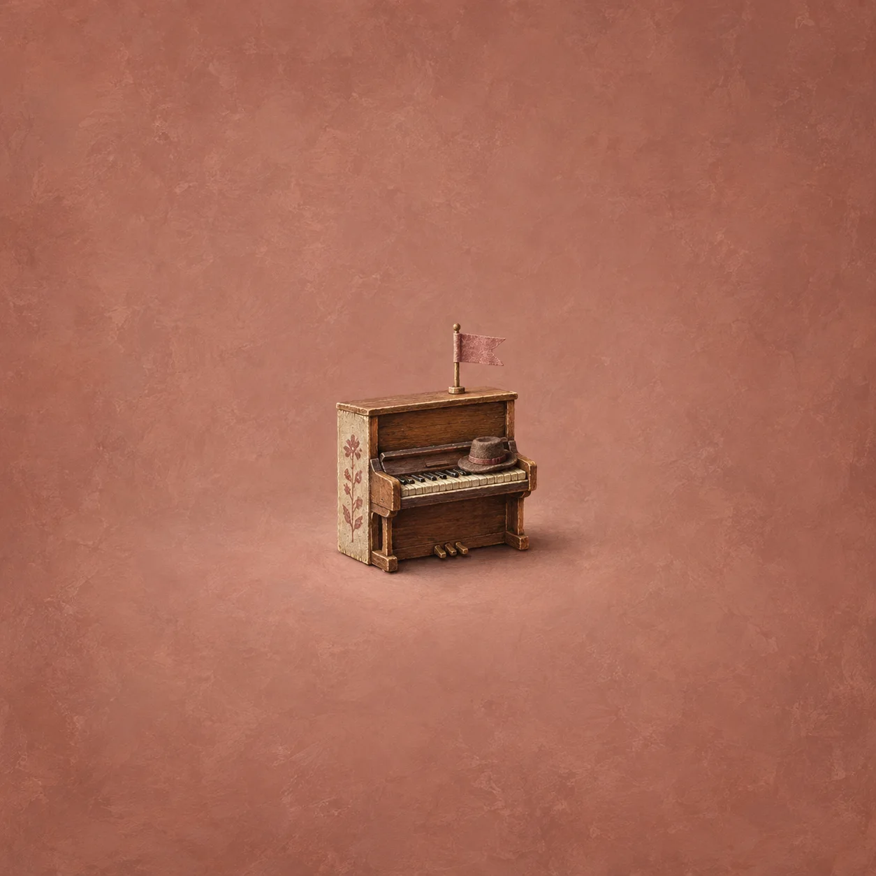A tiny upright wooden piano has a paper flag above it and a small hat resting on the keys.
