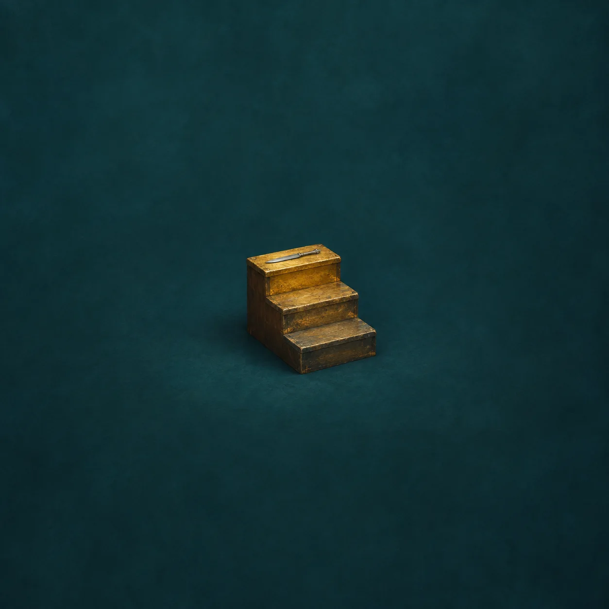 Three small wooden steps in fading gold tones, with a silver letter opener lying on the top step.
