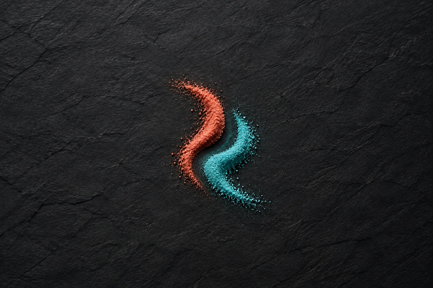 Separate curved trails of coral and turquoise sand lie on dark slate.