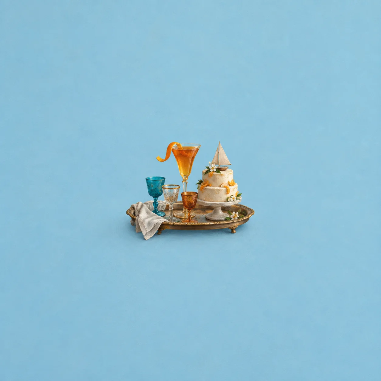 A tray of mismatched goblets beside a tiny tiered cake topped with a paper sail.