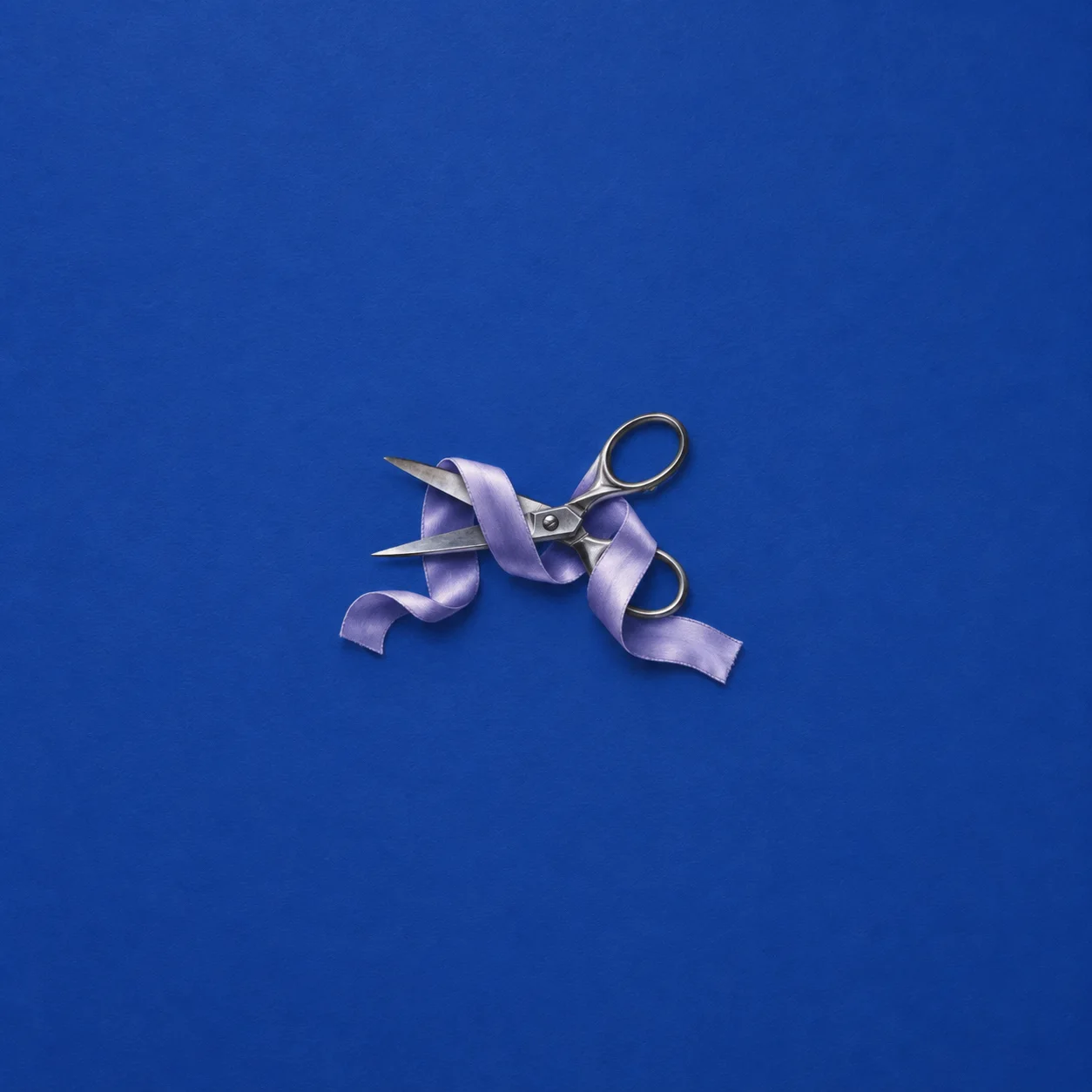Metal scissors wrapped in lavender ribbon against a cobalt-blue background.