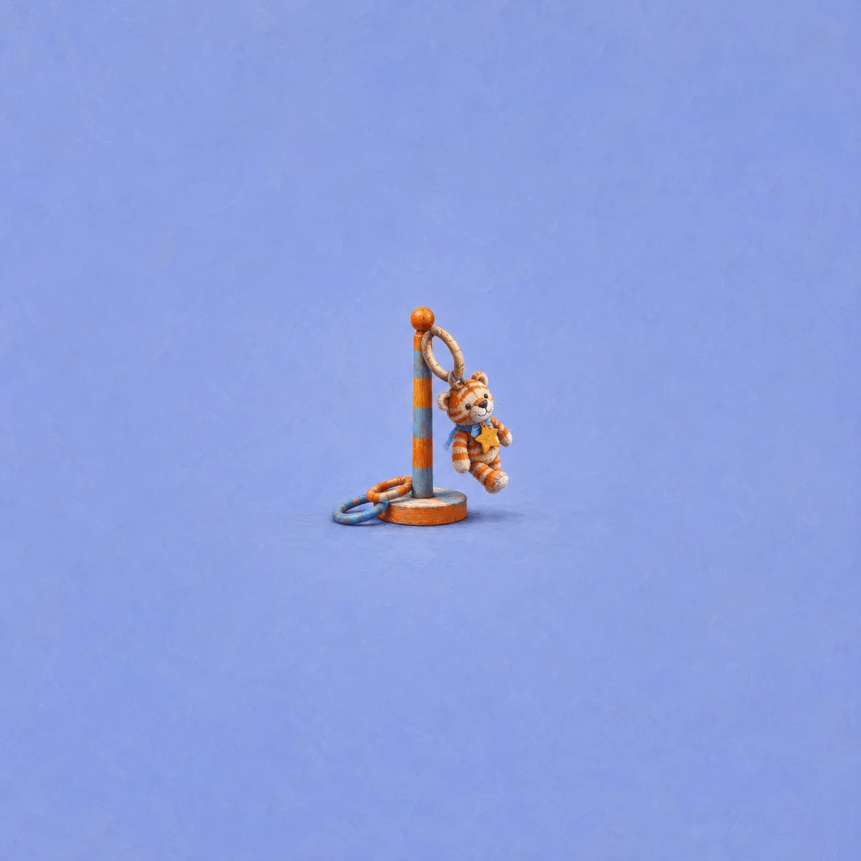 A striped plush toy hanging from a small orange ring-toss post, with loose rings at its base on a blue background.