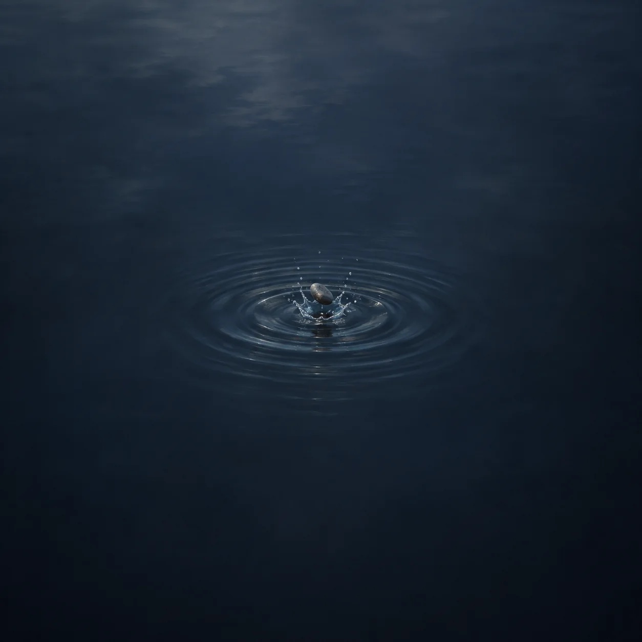 Painterly small pebble splashing into dark water with spreading circular ripples.
