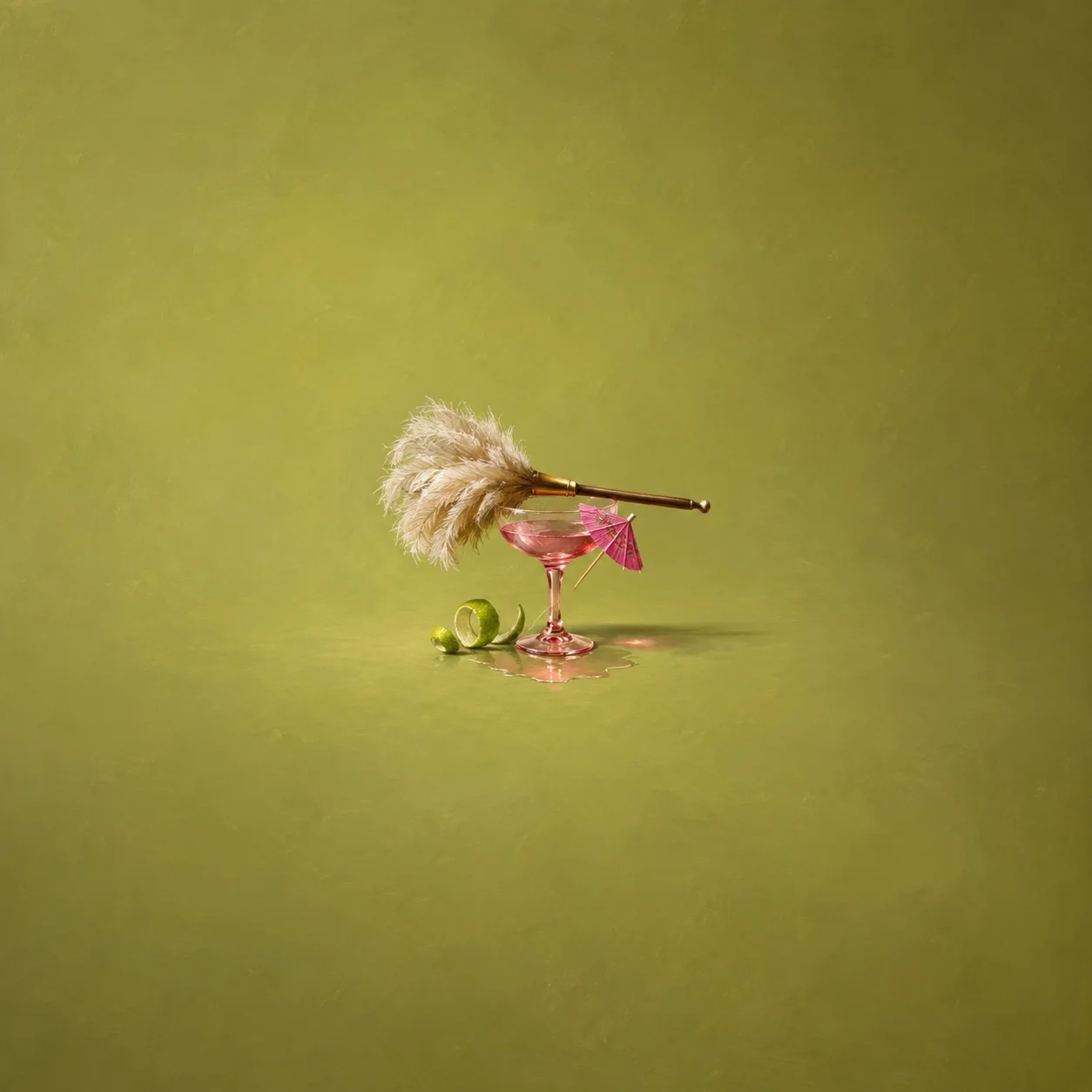 A feather duster lies across a pink cocktail glass with a small paper umbrella and curled lime peel against yellow-green.