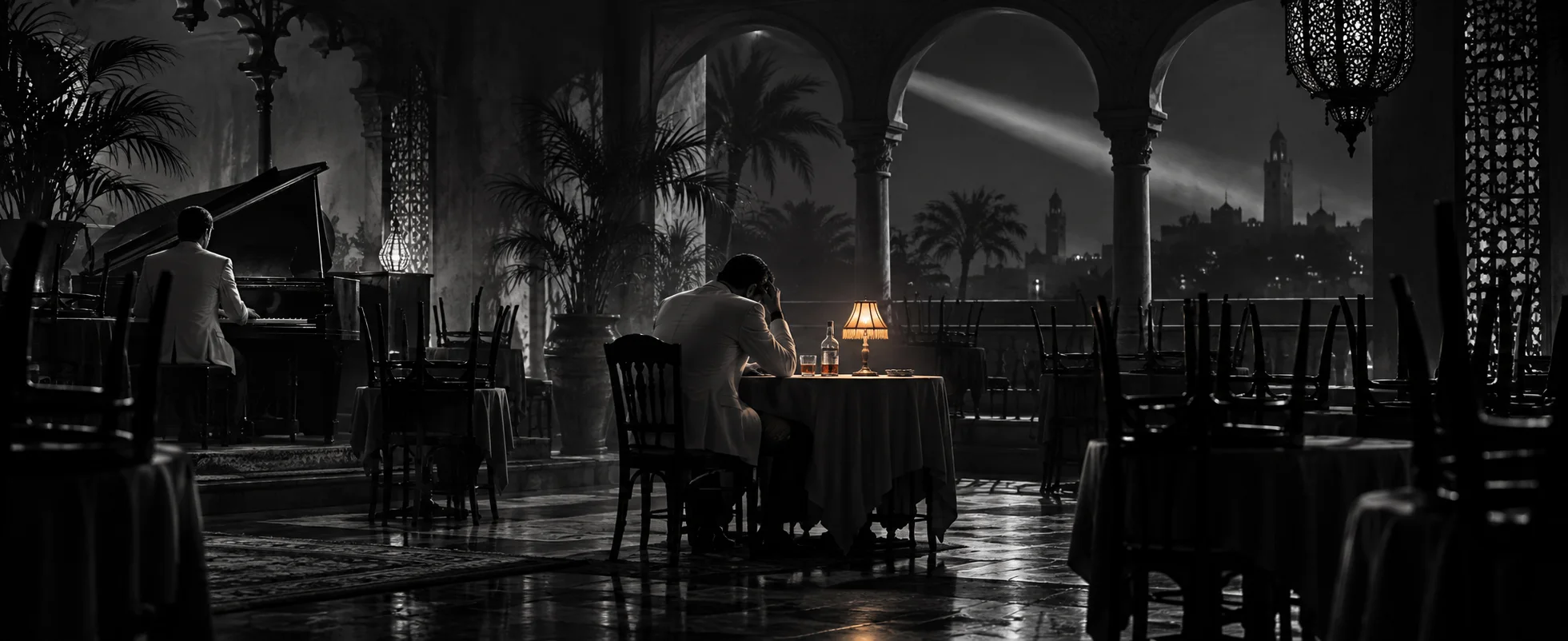 In black and white, a man slumps alone at a table with a bottle in an empty nightclub after closing, chairs upturned, the pianist playing softly nearby.