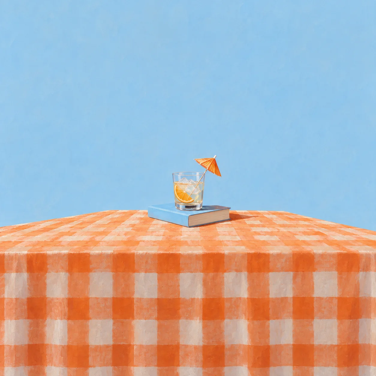 A pale blue closed paperback with a small glass on top holding a paper umbrella, on an orange checkered cloth.