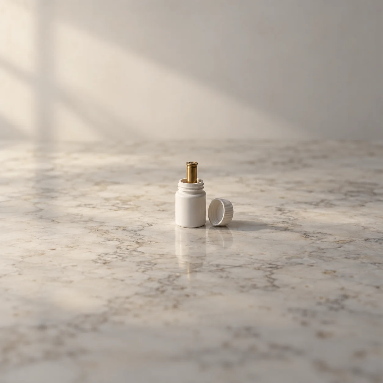 Painterly brass cartridge case standing in an open white pill bottle on marble, with its cap beside it.