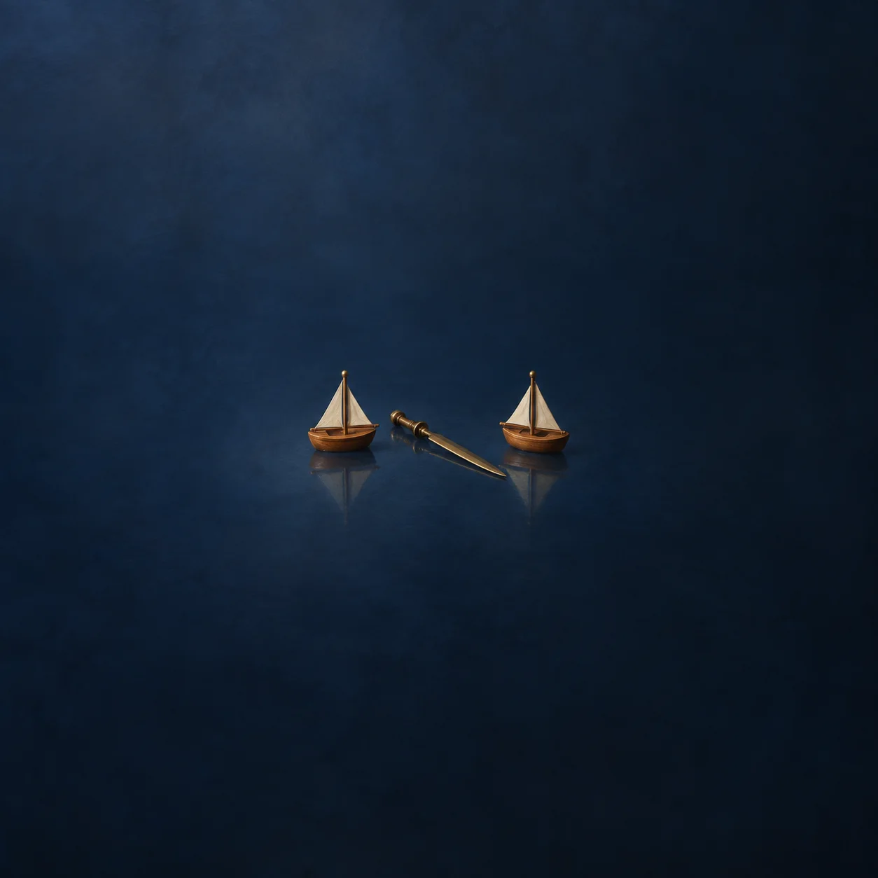 Two small wooden sailboats on dark blue glass with a brass sword lying between them.