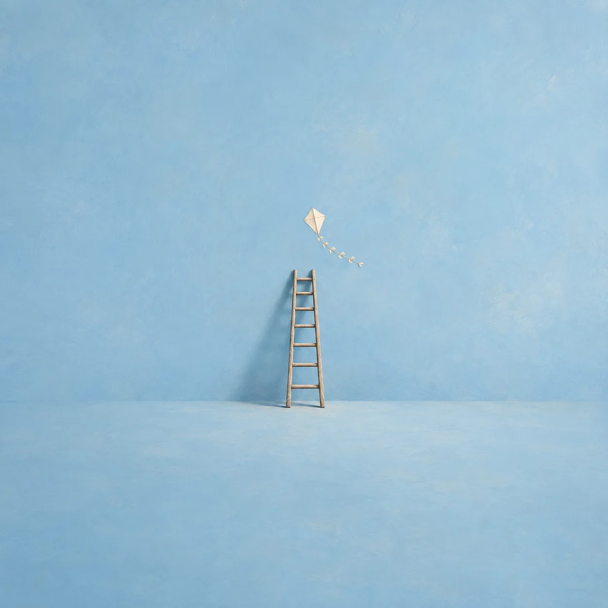 A thin wooden ladder against a pale blue wall with a paper kite hovering above the top rung.
