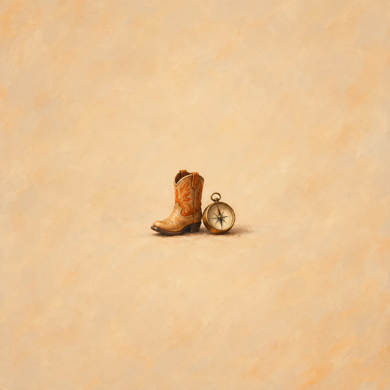 Miniature tan cowboy boot beside an unmarked round compass