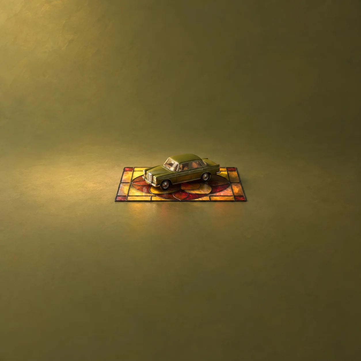 An olive-green toy car resting on a flat panel of amber and red stained glass.