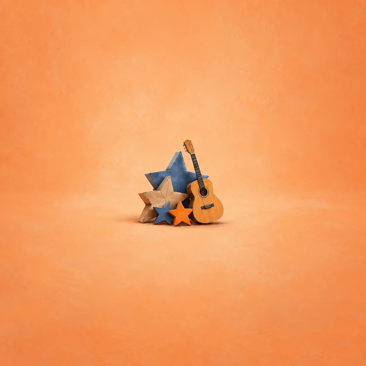A miniature acoustic guitar leans against blue and orange cardboard stars on a peach surface.