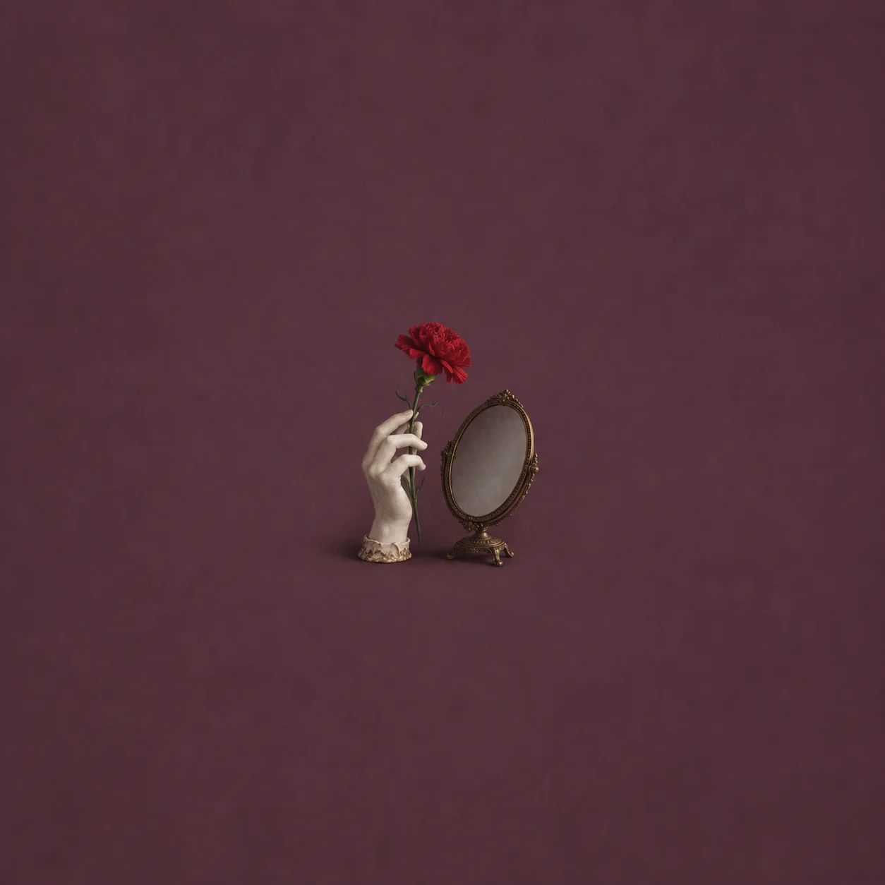 A white porcelain hand holds a red carnation beside a small oval mirror on a stand against plum.