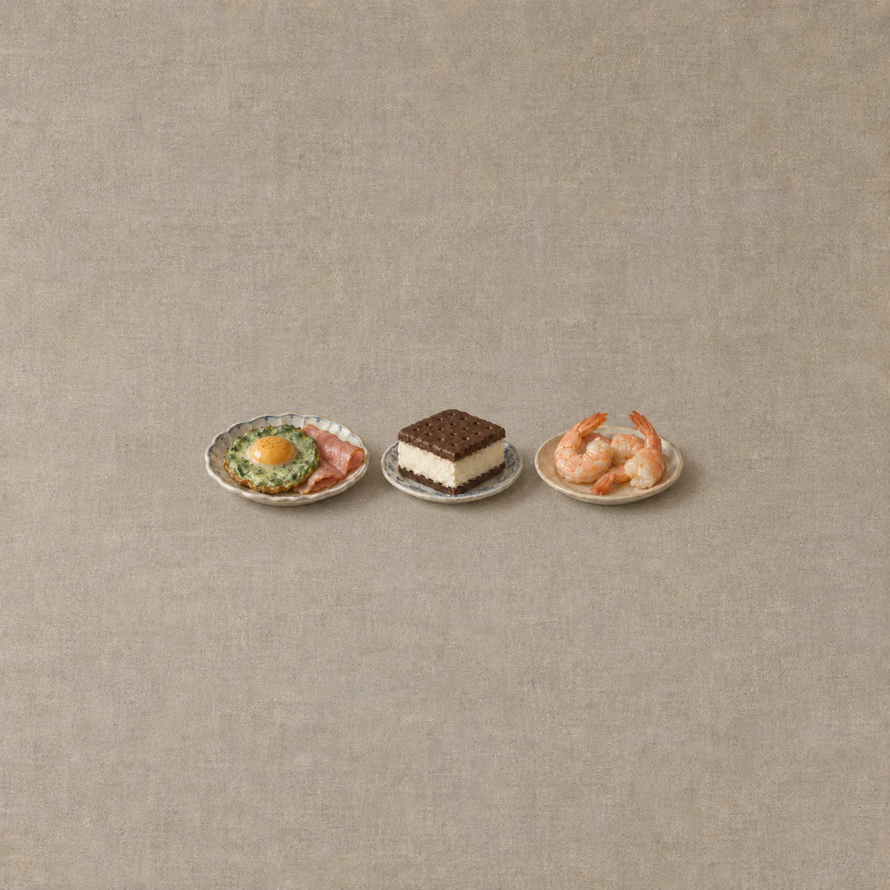 Green fried egg and ham, an ice cream sandwich and three pink shrimp sit on separate small plates.
