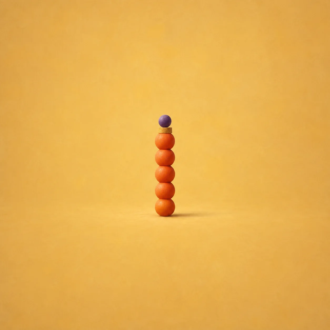A vertical stack of orange balls topped by a smaller violet ball on a golden-yellow background.