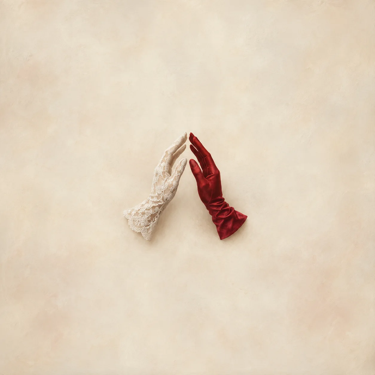 Painterly white lace glove and red satin glove raised with their fingertips almost touching.