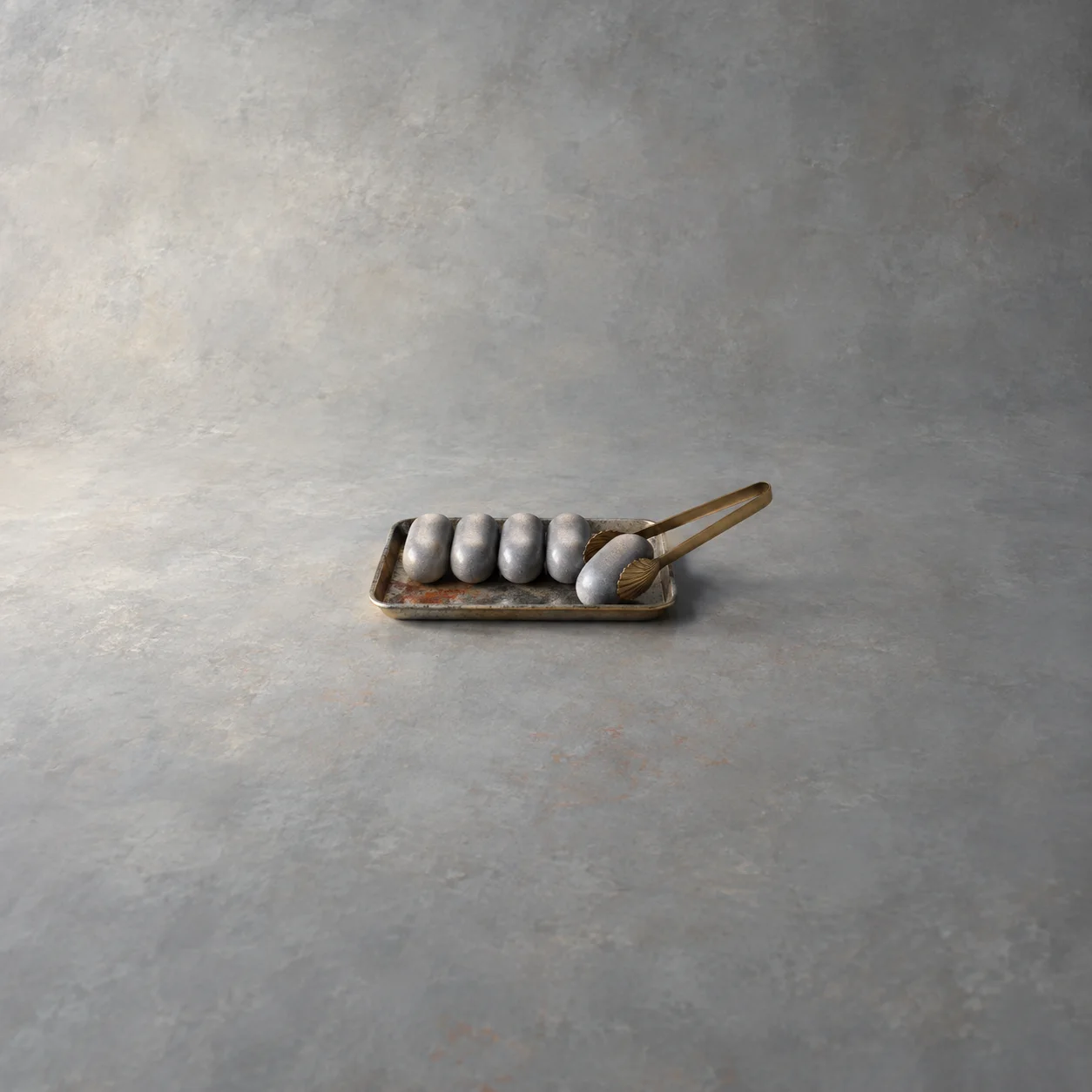 Gray soap bars arranged on a metal tray, with tongs holding one forward against a gray background.