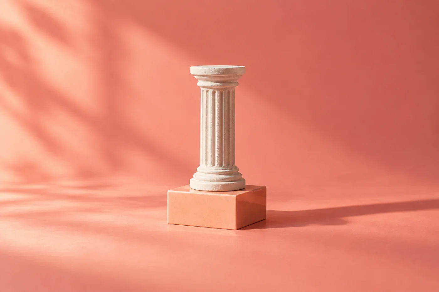 A small white fluted column stands on a peach plinth in warm light.