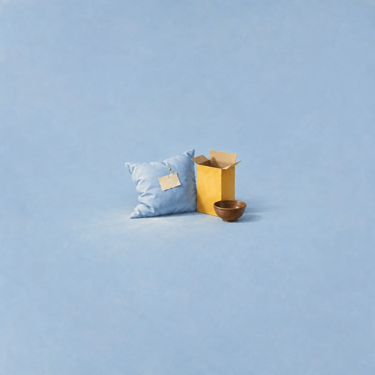 A blue pillow with a small blank note sits beside an open yellow carton and a brown bowl.