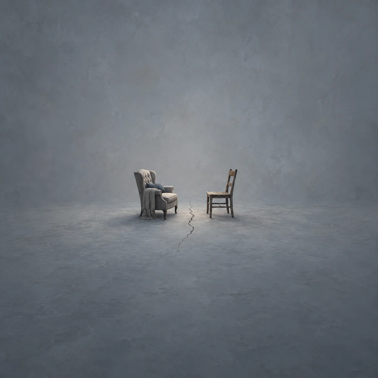 Painterly cushioned armchair facing a bare wooden chair across a crack in a grey floor.