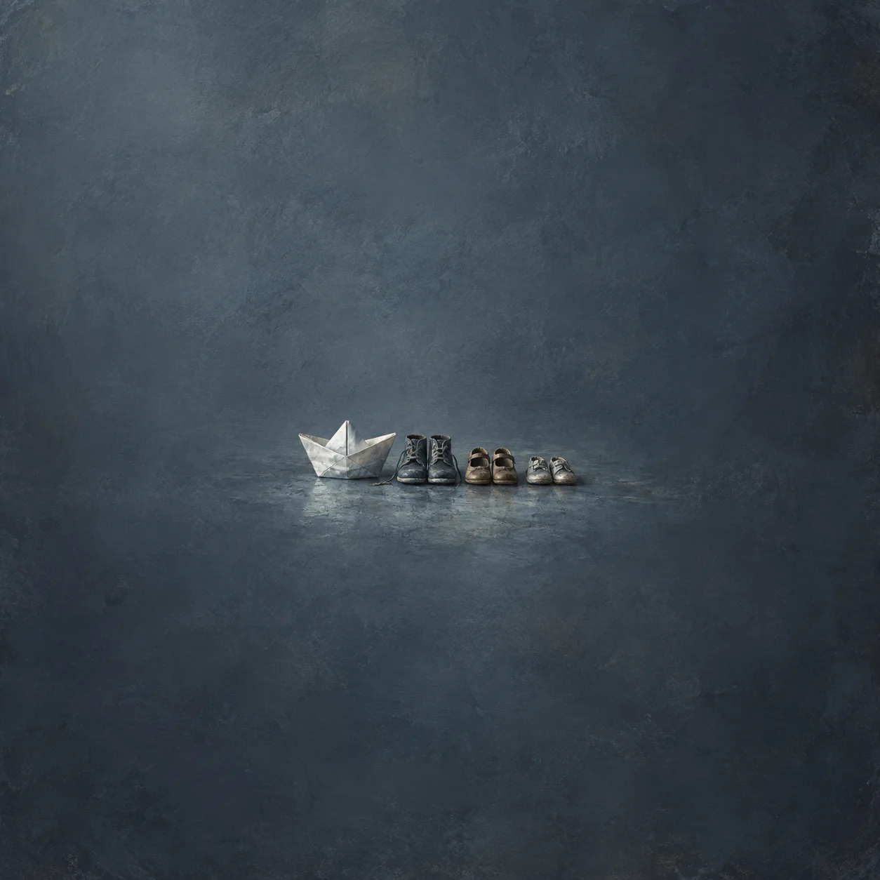 A white paper boat rests beside three pairs of small shoes on a blue-gray surface.