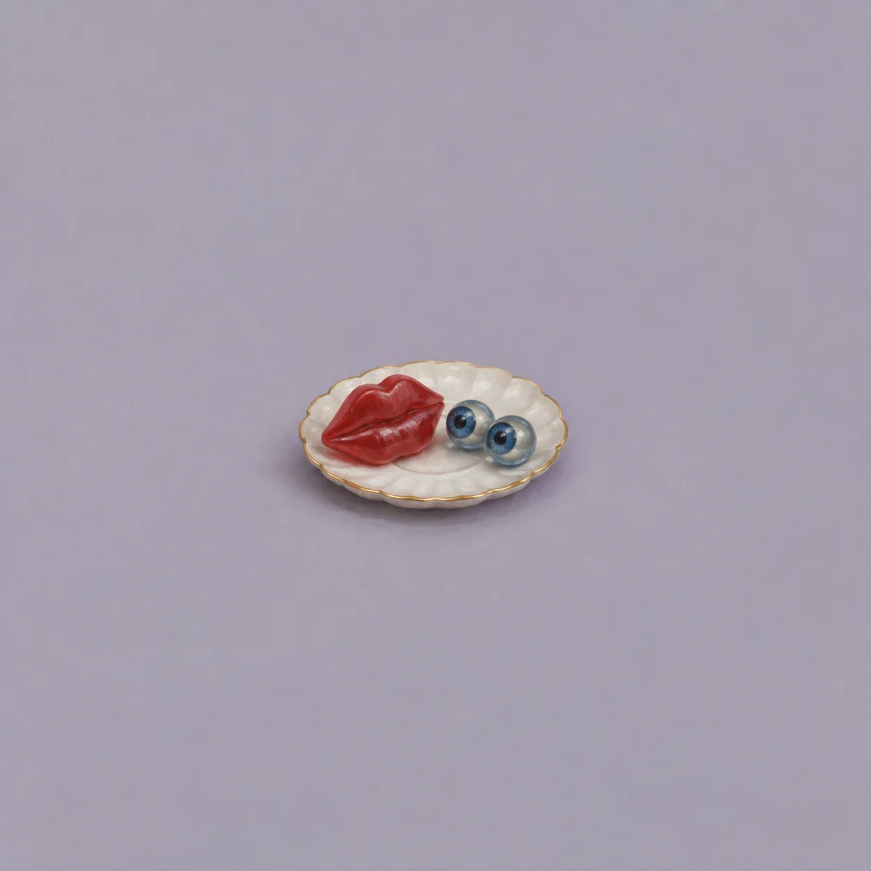 Red sculpted lips and two blue glass eyes rest on a white saucer.