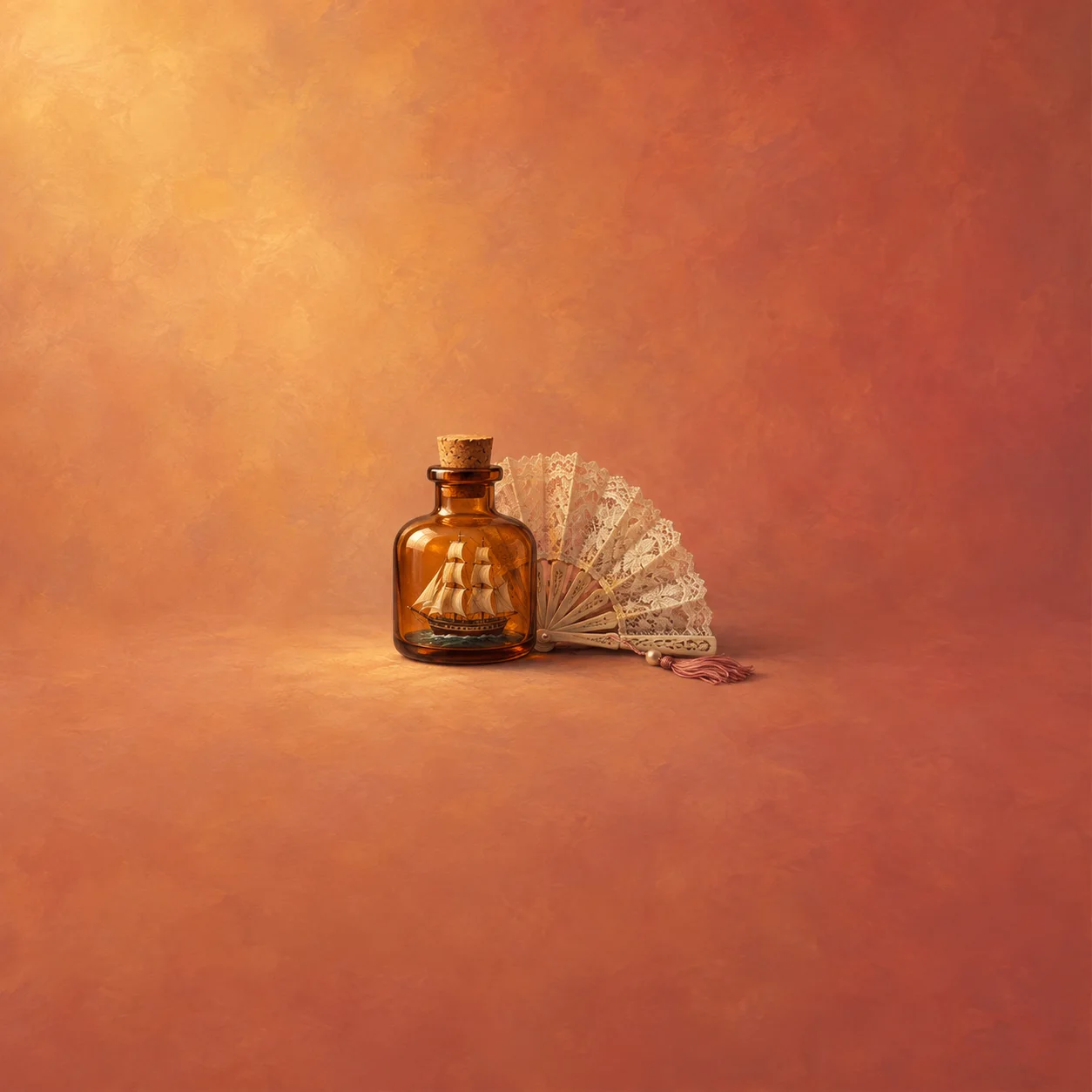 A tiny sailing ship sits inside a corked amber bottle beside an open lace fan on warm orange.
