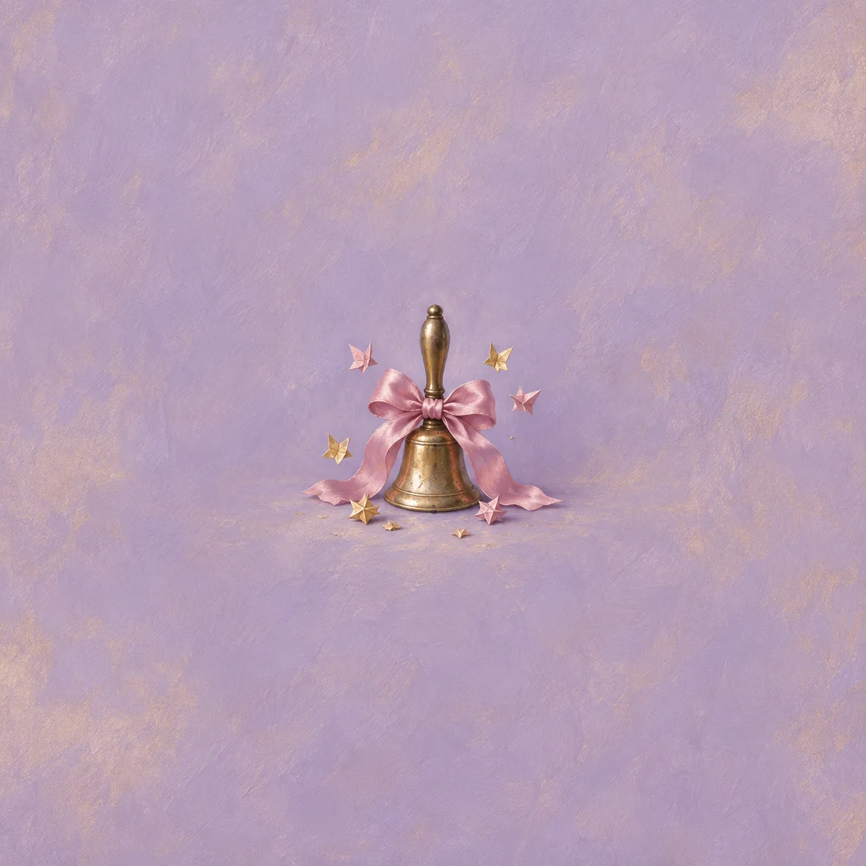 A brass handbell tied with a pink satin bow stands among small folded paper stars.