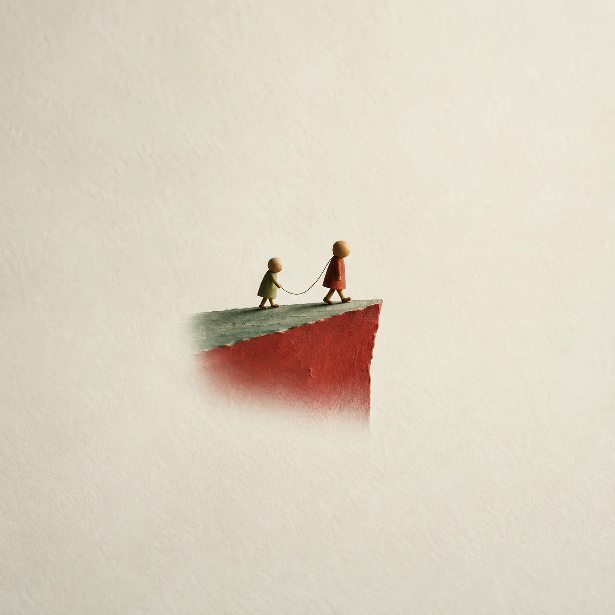 Two small wooden figures joined by a thread walking towards the edge of a red-and-green paper ledge.