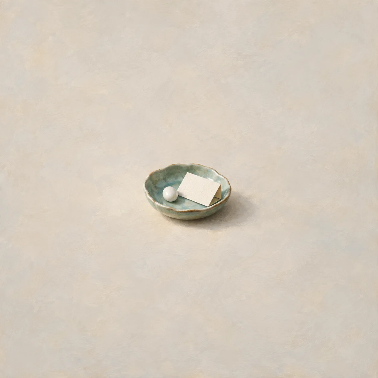 A small white pill and folded blank paper rest in a pale green ceramic dish on cream ground.