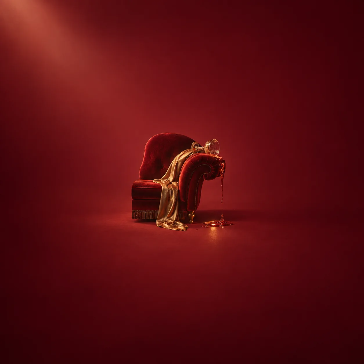 A tipped ornate glass spills amber liquid across the red velvet arm of an armchair.